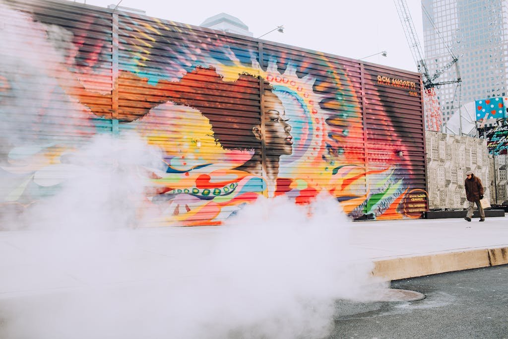 Man Walking On Sidewalk With Wall Painting