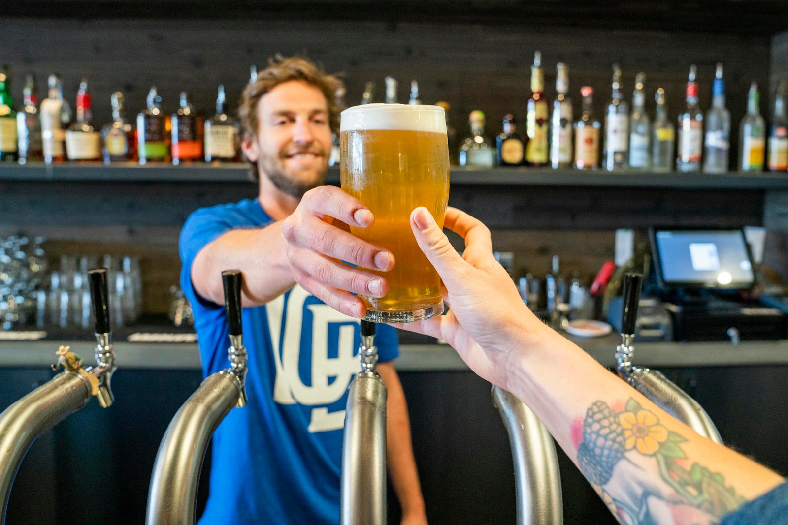 Man giving a glass of beer to a person