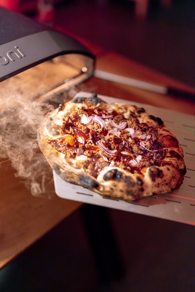 A pizza is being cooked on a grill