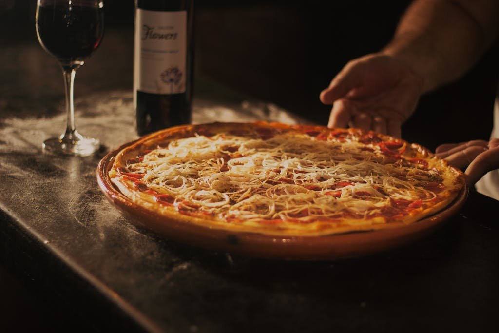 Person Holding Pepperoni Pizza on Tray