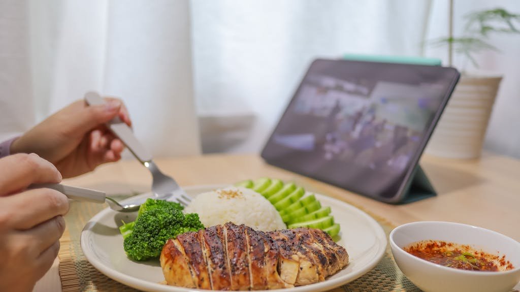 Closeup of a Person Eating Dinner and Looking at Laptop Screen