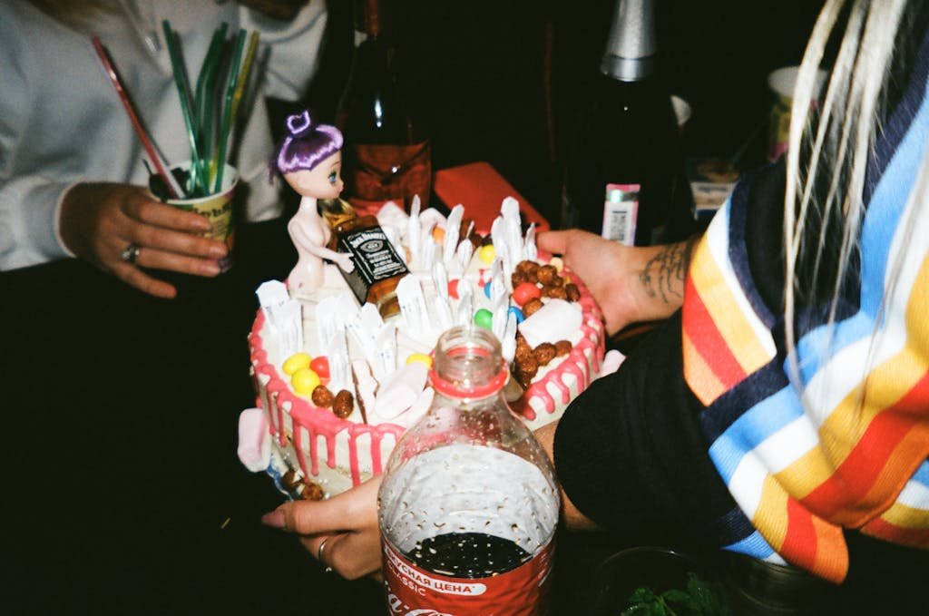 Person Holding Cake In Front Of Table