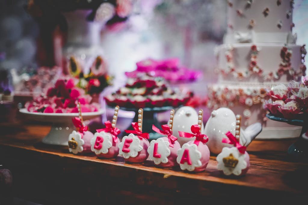 Pink and White Party Favors on Table With Cake