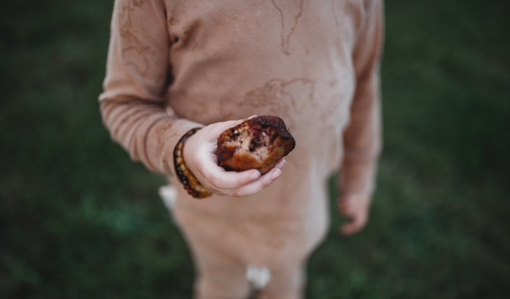 A child enjoying a delicious muffin outdoors in Austin, TX.