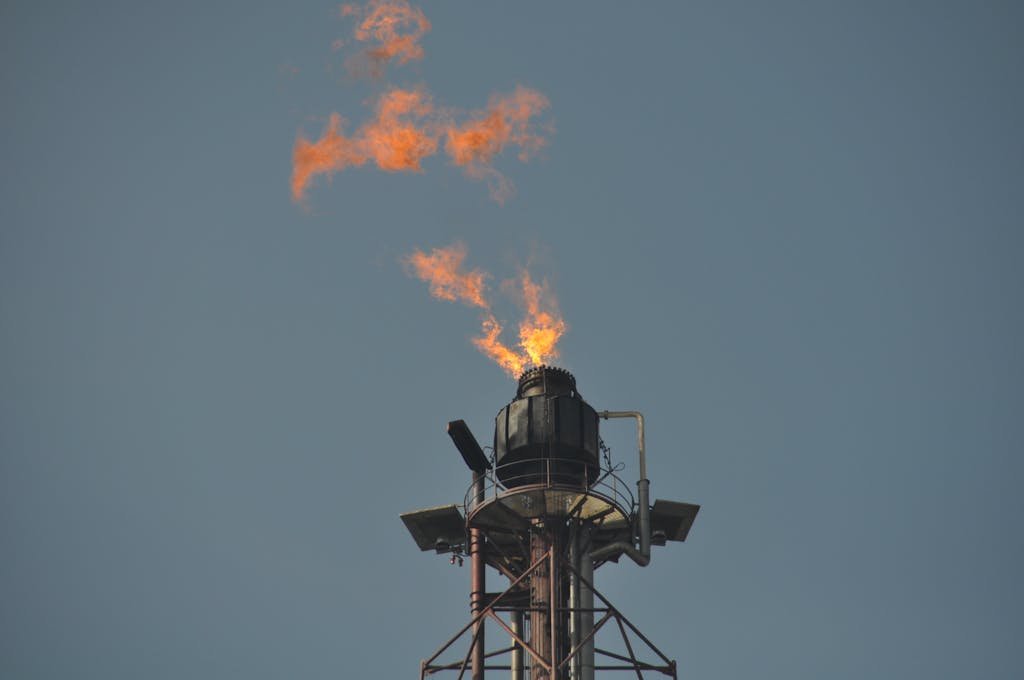 Flare stack releasing flames at an industrial site.