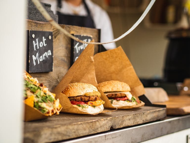 Savor gourmet burgers at an Amsterdam food festival, showcasing vibrant street food culture.